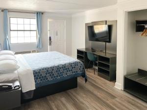 1 dormitorio con 1 cama y TV de pantalla plana en Motel 6-Monroe, LA en Monroe