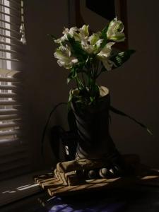 um vaso com flores brancas sentado numa mesa em Casa tranquila em Mosquera