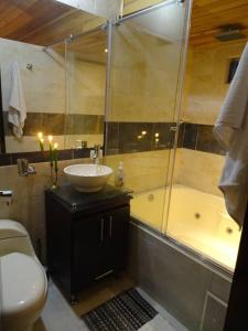 uma casa de banho com um lavatório, uma banheira e um WC. em Casa tranquila em Mosquera