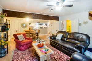 a living room with a leather couch and a table at St Simons Island Condo with Deck and Outdoor Shower in Saint Simon Mills