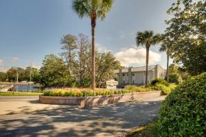 a garden with palm trees and flowers in a park at St Simons Island Condo with Deck and Outdoor Shower in Saint Simon Mills