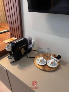 een aanrecht met een koffiezetapparaat en kopjes op een tafel bij Hotel Castel in Râmnicu Vâlcea