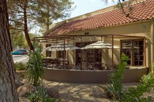 un restaurante con mesas y sombrillas en un edificio en Embassy Suites by Hilton Phoenix Tempe, en Tempe