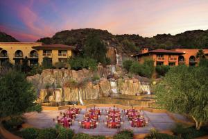 un groupe de tables et de chaises devant une cascade dans l'établissement Hilton Phoenix Tapatio Cliffs Resort, à Phoenix