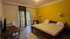 1 dormitorio con cama, escritorio y ventana en AR Sun Hotel, en Antsiranana
