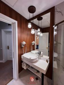 a bathroom with a sink and a mirror at Hotel Castel in Râmnicu Vâlcea