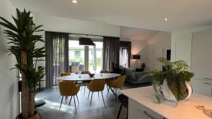een keuken en een woonkamer met een tafel en stoelen bij VILLA ARYVE in See-, Strand- und Golfplatznähe inklusive NETFLIX, Bad en Suite und Wohlfühlgarantie in Dirkshorn