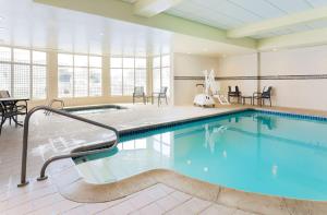 a pool in a room with chairs and tables at Hilton Garden Inn Reno in Reno