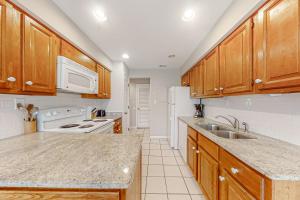 a kitchen with wooden cabinets and a white refrigerator at Turtle Cove 5546 in Kiawah Island
