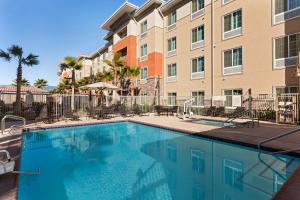 una piscina con sillas y un edificio en Hampton Inn & Suites San Bernardino, en San Bernardino