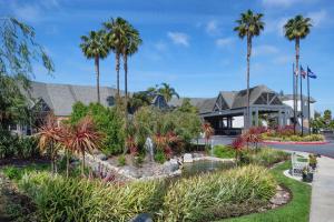 a garden in front of a house with palm trees at Hilton San Diego/Del Mar in San Diego