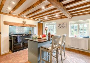 Wisteria Cottage في Snape: مطبخ مع طاولة وكراسي في غرفة
