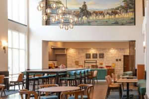 a restaurant with tables and chairs and a kitchen at Hampton Inn & Suites Boerne in Boerne