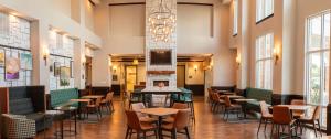 a restaurant with tables and chairs in a room with windows at Hampton Inn & Suites Boerne in Boerne