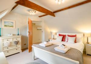 a bedroom with a large bed with two towels at Wisteria Cottage in Snape