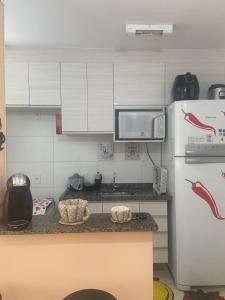 uma cozinha com armários brancos e um frigorífico branco em Apartamento Mari 1 em São Carlos