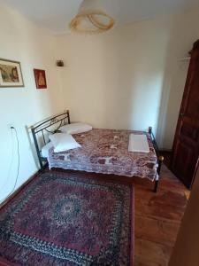 Dormitorio pequeño con cama con alfombra en Archontiko Maros, en Mouresi