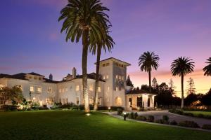 uma casa grande com palmeiras em frente em Hayes Mansion San Jose, Curio Collection by Hilton em San Jose