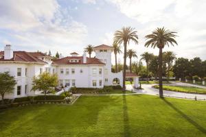 an exterior view of a mansion with palm trees at Hayes Mansion San Jose, Curio Collection by Hilton in San Jose