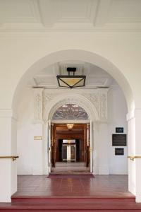 ein Torbogen, der in ein Gebäude mit einem Flur führt in der Unterkunft Hayes Mansion San Jose, Curio Collection by Hilton in San Jose