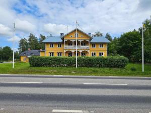 uma grande casa amarela ao lado de uma estrada em Lokatten Wärdshus em Los