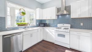 a white kitchen with white cabinets and a window at Classic 1 Bedroom Apt in Midtown, ATL in Atlanta