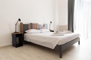 una camera bianca con un grande letto con due lampade di home72 a Trani