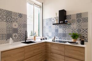una cucina con piastrelle bianche e blu sul muro di home72 a Trani