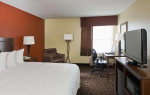 a hotel room with a bed and a flat screen tv at Hampton Inn San Angelo in San Angelo