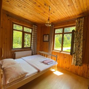a bedroom with a bed in a wooden room at Nanus Ayder Apart and Restoran in Rize