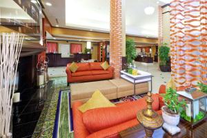 a lobby with two orange couches and a fireplace at Hilton Garden Inn Fontana in Fontana