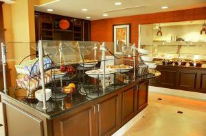 un buffet in una cucina con molti piatti di Hilton Garden Inn Fontana a Fontana