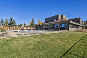 a house with a lawn and chairs in front of it at Family-Friendly Fraser Condo with Heated Pool Access in Fraser