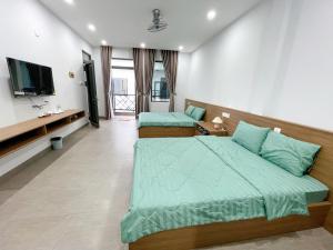 1 dormitorio con 2 camas y TV de pantalla plana en Cá House en Quy Nhon
