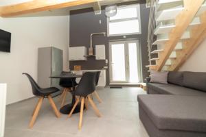 a living room with a couch and a table and chairs at La Casetta 117 in Cagliari