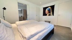 une chambre avec un lit et un tableau au mur dans l'établissement VILLA ARYVE in See-, Strand- und Golfplatznähe inklusive NETFLIX, Bad en Suite und Wohlfühlgarantie, à Dirkshorn