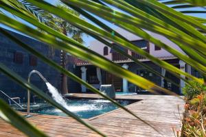 a pool with a water fountain in a yard at Hotel Boutique Ses Pitreras in San Antonio Bay