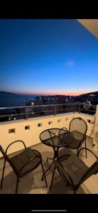 two chairs and a table on top of a balcony at Villa Idrizi in Sarandë