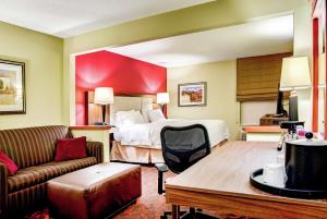 a hotel room with a bed and a couch at Hampton Inn St. Joseph in Saint Joseph