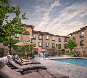 a hotel with a pool and chairs and an umbrella at Hampton Inn & Suites Windsor-Sonoma Wine Country in Windsor