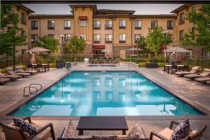a swimming pool at a hotel with chairs and a building at Hampton Inn & Suites Windsor-Sonoma Wine Country in Windsor