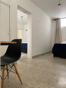 um quarto com uma secretária e uma cadeira. em Aparta Hotel Mediterráneo Estadio em Medellín