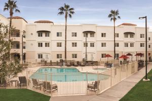 un hotel con piscina y palmeras en Homewood Suites Tucson St. Philip's Plaza University, en Tucson