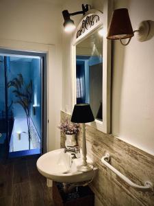 a bathroom with a sink and a mirror and a lamp at La Casica del Abuelo Valentín 