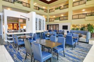 a dining room with tables and blue chairs at Embassy Suites Valencia in Valencia