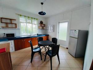 uma cozinha com uma mesa e cadeiras e um frigorífico em Coral Apartment ( 5 bedroom apartment) em Grand Gaube