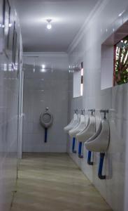 La salle de bains est pourvue de 4 urinoirs et d'une rangée de lavabos. dans l'établissement Shose Campsite, à Shiri