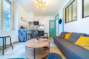 un soggiorno con divano e tavolo di Le Jean Jaures- 2 chambres- Gerland-Tony Garnier a Lione