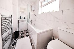 a white bathroom with a sink and a toilet at Cassia, 3 Bedrooms, Sleeps 5 