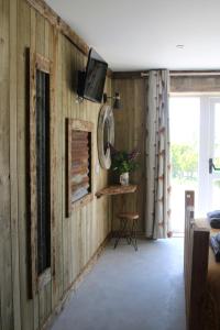 sala de estar con paneles de madera y TV en la pared en The Moo-tel at Bargoed Farm en Aberaeron